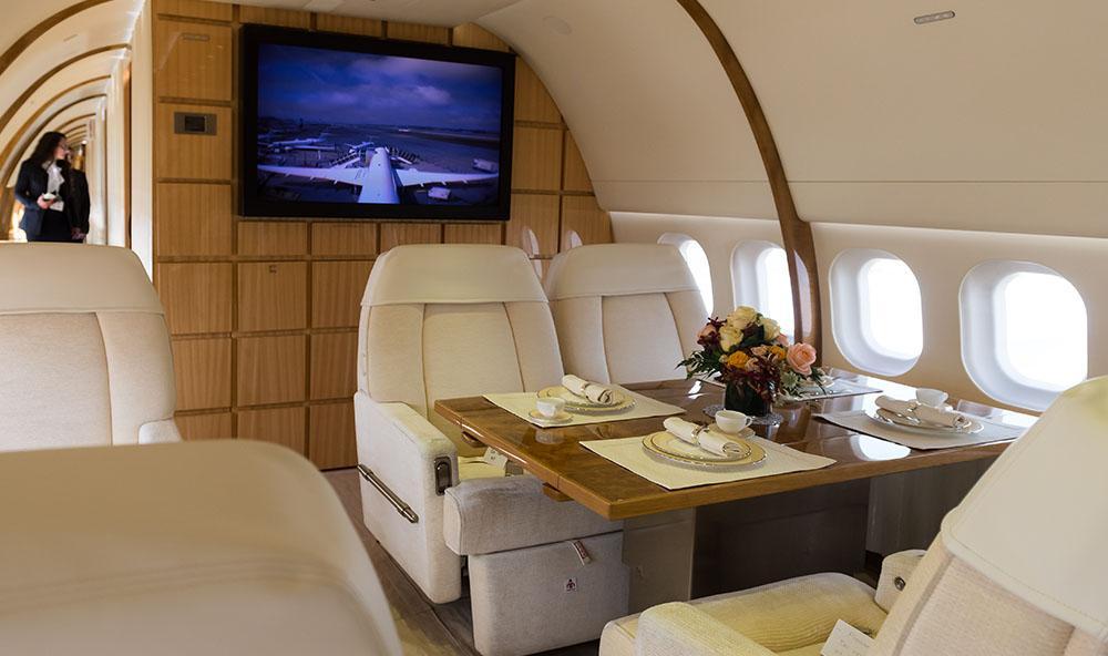 Aircraft interior including white seats and a dinner table