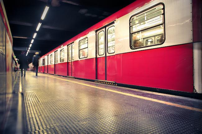 A train platform with a red and white train stopped